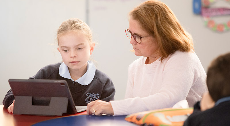 St Bernadette's Catholic Primary Castle Hill teacher supporting a student during lesson