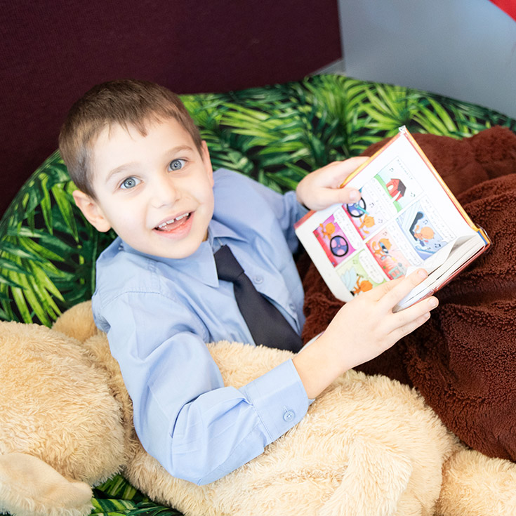 Happy boy reading in the St Bernadette's Catholic Primary Castle Hill school library